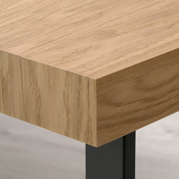Gros plan du coin de la table en bois ; Finition placage de chêne lisse, bord métallique robuste.