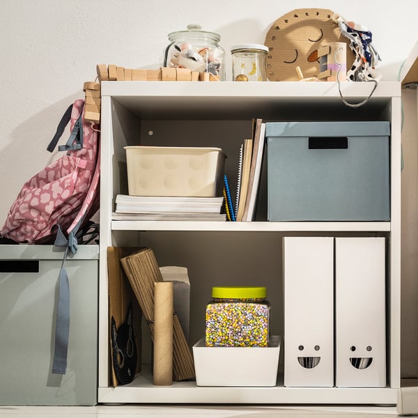 Étagère avec classeurs de magazines TJABBA en bleu et blanc, boîtes en carton. Comprend des boîtes, des papiers, des bocaux, des jouets en bois, un sac.
