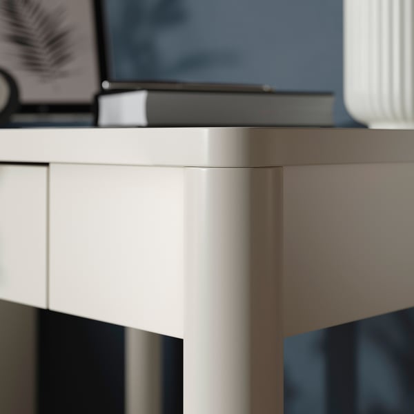 Gros plan d’un bureau moderne de haute qualité avec une finition élégante et blanc cassé et un tiroir à fermeture douce.