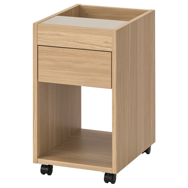 Un meuble à tiroirs en bois de chêne clair TONSTAD sur roulettes, au design simple.