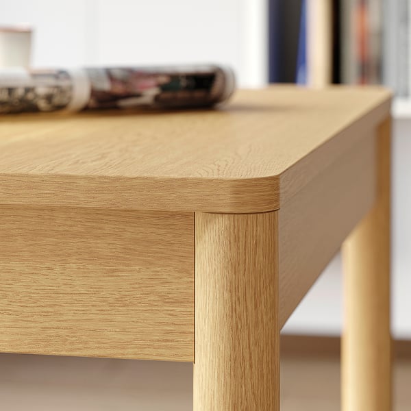 Détail de la table en bois : finition lisse et légère ; Bords arrondis et robustes.
