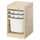 Un meuble de rangement TROFAST, en bois clair, avec trois plateaux blancs et une grande poubelle blanche. Il a une forme rectangulaire et un design ouvert à l’avant.