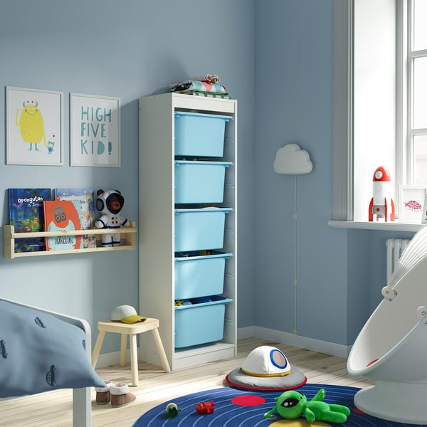 Chambre d’enfant avec rangement de jouets et de livres TROFAST bleu, cadre blanc, étagère murale, art monstre.