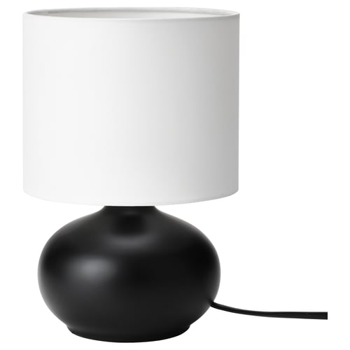 Lampe de bureau moderne, TVÄRFOT. Base ovale en grès noir. Abat-jour cylindrique blanc. Design simple et élégant.
