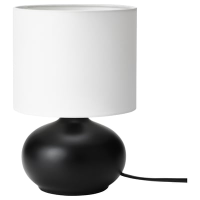 Lampe de bureau moderne, TVÄRFOT. Base ovale en grès noir. Abat-jour cylindrique blanc. Design simple et élégant.