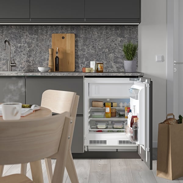 Cuisine avec réfrigérateur compact ouvert, étagères éclairées par led.