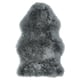 Un tapis en peau de mouton gris ULLERSLEV avec une texture douce et hirsute, une forme rectangulaire et des variations naturelles.