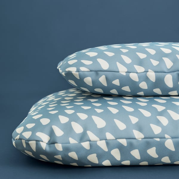 Deux coussins ronds pour animaux de compagnie avec des housses à motifs blancs, conçus pour le confort et la durabilité, idéaux pour une utilisation en intérieur.