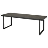 Une table d’extérieur VÄRMANSÖ noire à l’aspect bois, fabriquée en aluminium et acier recyclés. Forme rectangulaire, design moderne.