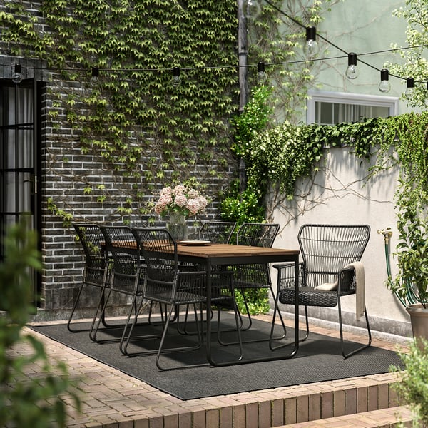 Ensemble de patio extérieur moderne avec table et chaises en métal noir, parfait pour les repas.