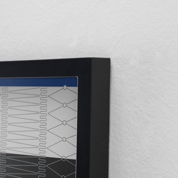 Présentoir de photos à cadre noir monté sur un mur blanc, présentant un design bien conçu, mettant l’accent sur une esthétique élégante et moderne.