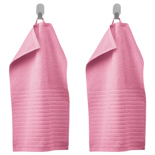 Deux serviettes roses VÅGSJÖN sont suspendues côte à côte sur des crochets métalliques, avec un design texturé doux et des couleurs vives.