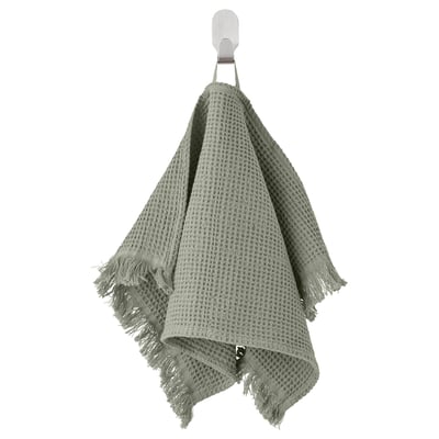 Serviette VALLASÅN verte, mélange de coton doux, forme gaufrée texturée, suspendue à un crochet mural.