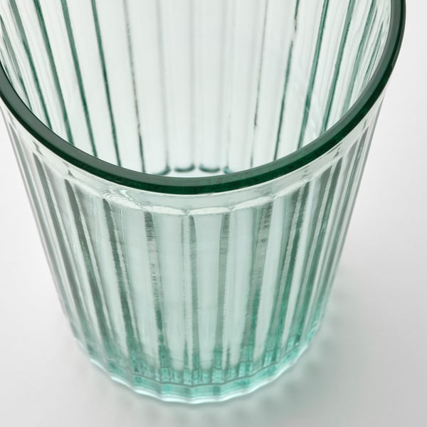 Tasse en verre transparent robuste avec des arêtes verticales, conçue pour la durabilité et l’élégance.