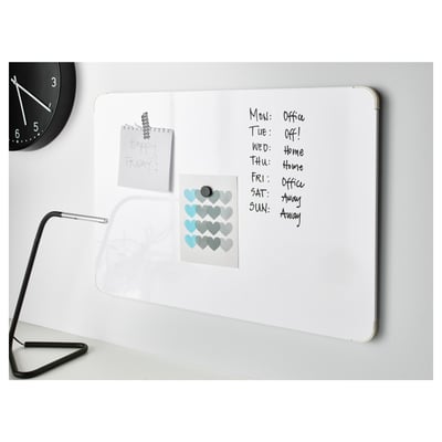 Un tableau blanc avec des notes d’horaire sous une horloge et une lampe, répertoriant les jours et les activités, avec des autocollants et une note de service.