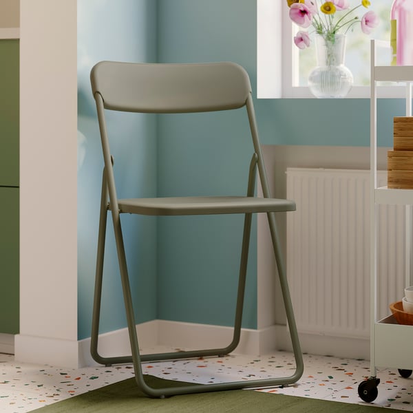 La chaise pliante grise VIHALS, élégante et compacte, s’intègre parfaitement dans une pièce moderne.