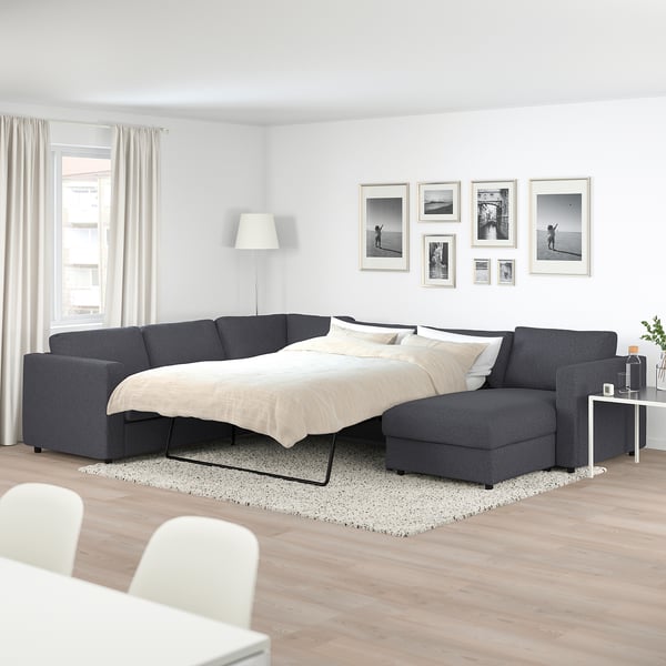 Canapé sectionnel VIMLE en gris, spacieux et moderne avec lit convertible, s’adapte parfaitement sous la galerie de photos, efficace et confortable.