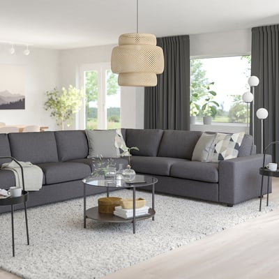 Salon moderne avec sectionnel, suspension et table basse VIMLE, fenêtres lumineuses, tapis et décoration.