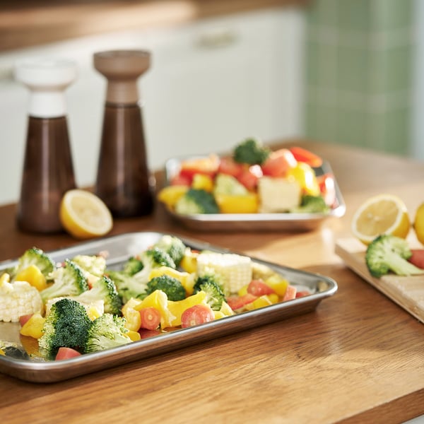 Un plan de travail de cuisine avec des légumes colorés, du citron et des assaisonnements.