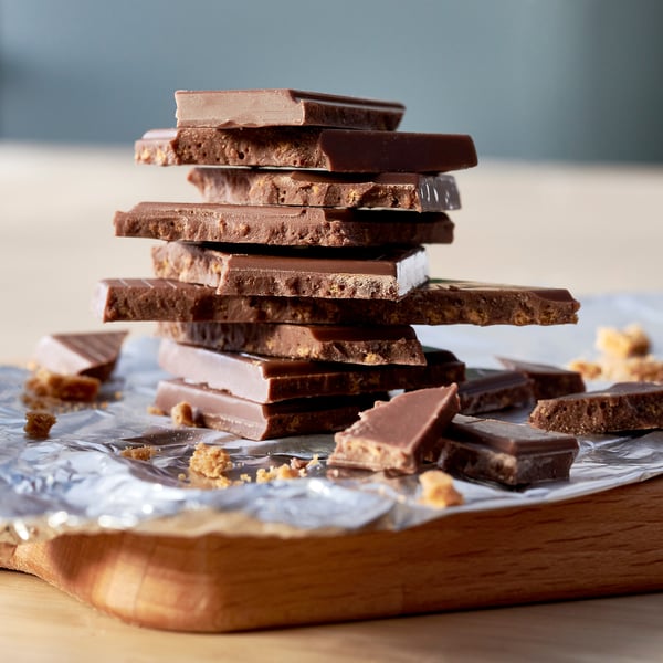 Chocolat au lait empilé avec des chapelures croustillantes de pain d’épices sur du papier aluminium.