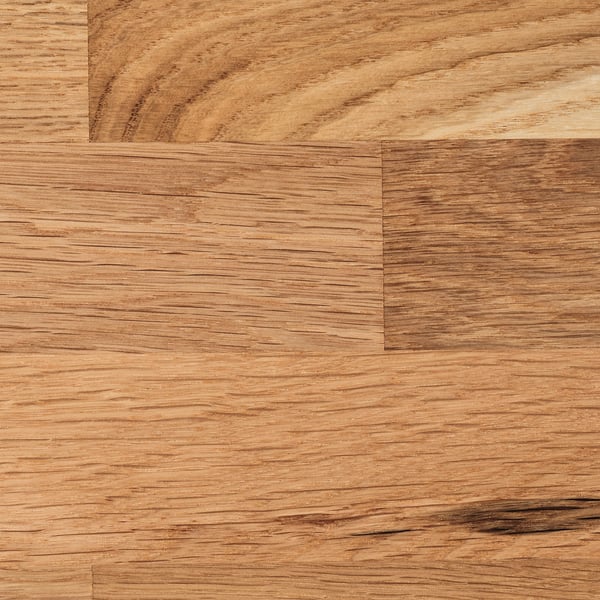 Gros plan d’un plan de travail en bois avec une texture de grain de chêne visible, mettant en valeur sa finition lisse et naturelle et son motif uniforme.