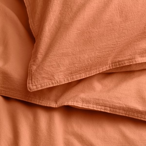 Zacht, gevouwen terracotta stof detail, met stiksels en textuur.