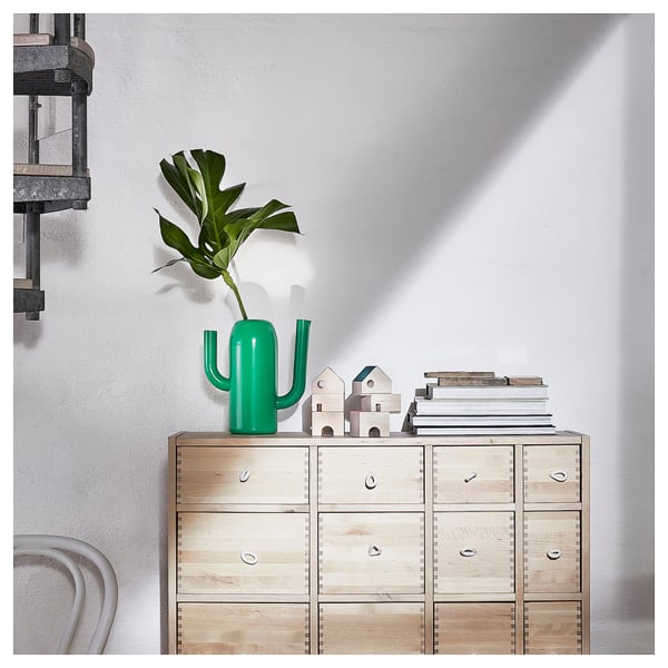 Cactusvaas ÄRTBUSKE op houten dressoir met plant, boeken en stoel.