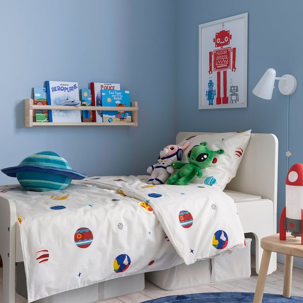 Kinderkamer met AFTONSPARV dekbed, planeten, sterren, blauwe muur, boekenplank, rode robotposter, blauw planeetkussen, groen speelgoed, rode raketlamp.