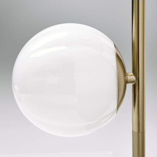 Strakke moderne lamp met een grote, ronde, witte glazen bolkap. Goudmetalen voet, elegant ontwerp.