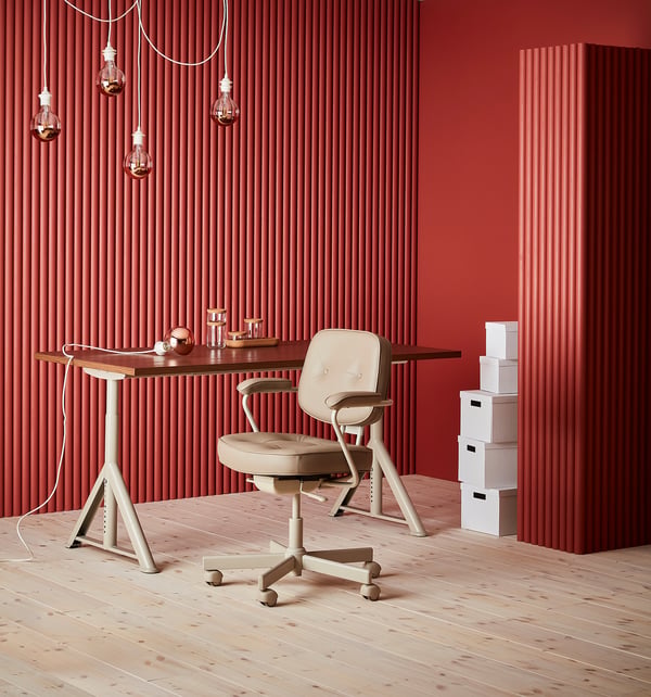 Modern thuiskantoor: beige ergonomische lederen stoel, houten bureau, rood gecanneleerde muren, witte opbergers, hanglampen.