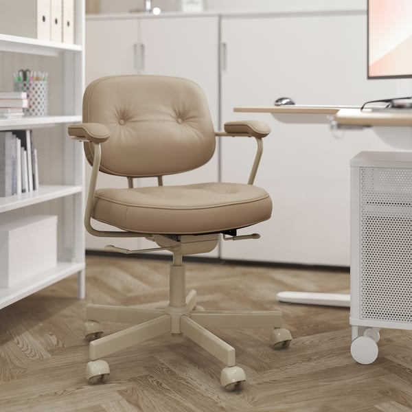 Modern kantoor aan huis: beige lederen ergonomische stoel met verstelbare armleuningen, zwenkwielen, in minimalistische witte kamer.