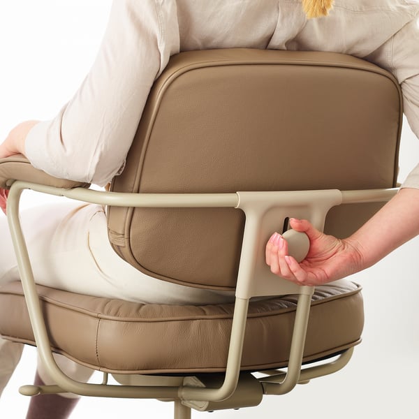 Persoon die de lendensteun op een ergonomische bureaustoel aanpast. De bedieningselementen bevinden zich aan de rechterkant en passen de stoel aan op hun lichaam voor comfort.
