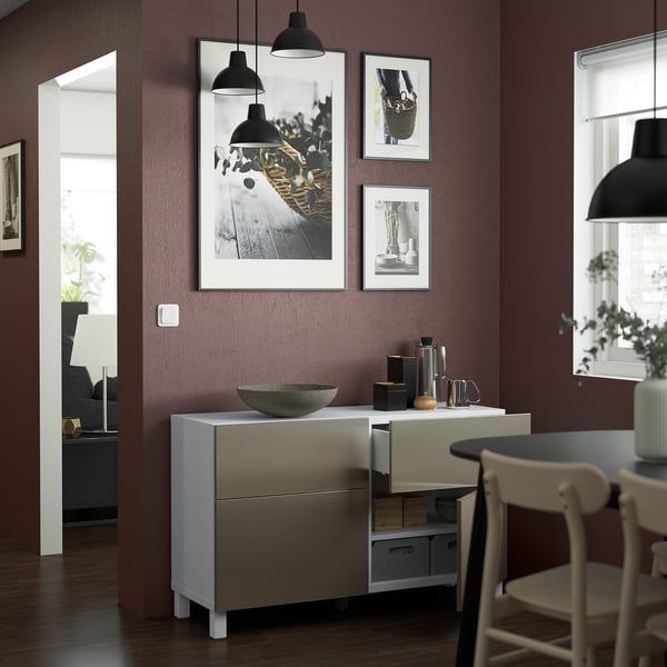 Moderne eethoek met wit BESTÅ dressoir met verstelbare planken en lades, met decoratieve voorwerpen onder minimalistische verlichting.