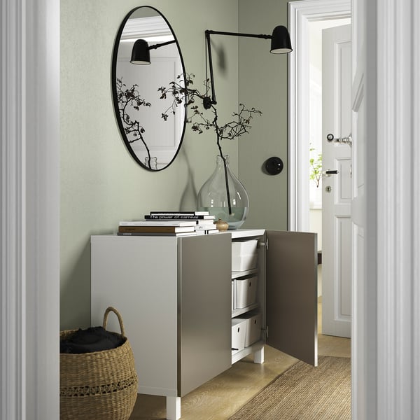 Moderne opbergunit met open compartiment, met technische apparatuur en decoratieve artikelen; Aangebouwde wandlamp en spiegel.