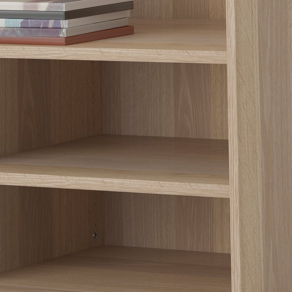 Houten boekenrek met drie lege planken en een stapel boeken bovenop. De planken zijn verstelbaar.