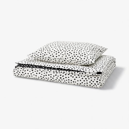 Een BJÖRKGRÅMAL dekbedset met zwarte stippen op een witte achtergrond, gemaakt van een zachte katoen- en viscosemix.