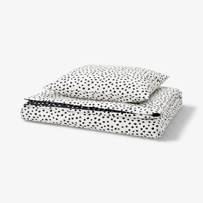 Een BJÖRKGRÅMAL dekbedset met zwarte stippen op een witte achtergrond, gemaakt van een zachte katoen- en viscosemix.