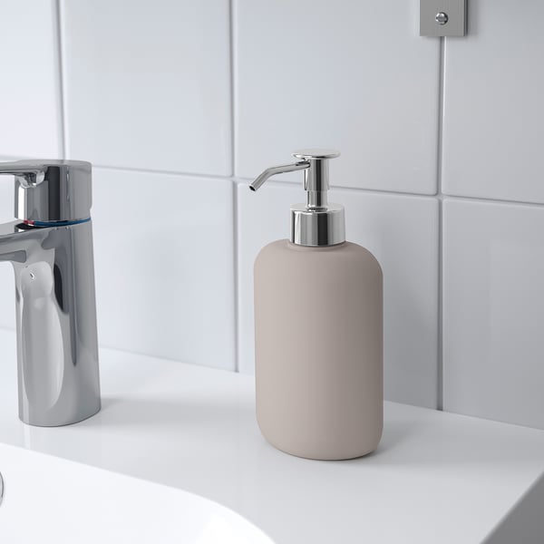 Zeepdispenser op een witte gootsteen, die een moderne stijl weerspiegelt, past bij andere accessoires uit de EKOLN-serie.