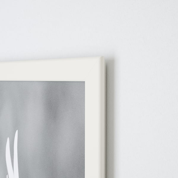 Een close-up van een witte FISKBO-fotolijsthoek op een lichte muur, met scherpe randen en een duidelijk ontwerp.