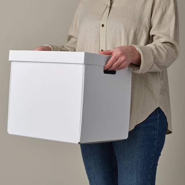 Persoon met witte opbergdoos met uitgesneden handgrepen, ideaal voor kallax rekken.