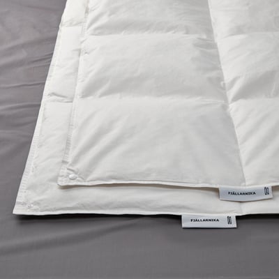 Afbeelding toont een netjes gerangschikt wit dekbed op een bed, met de nadruk op de gladde, frisse stof en het kwaliteitsontwerp.