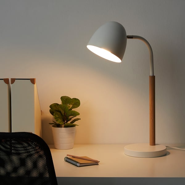 Moderne bureaulamp, FRANSALG, met groenachtige kap, houten voet. Het licht richt zich naar beneden. Plant en notities in de buurt.