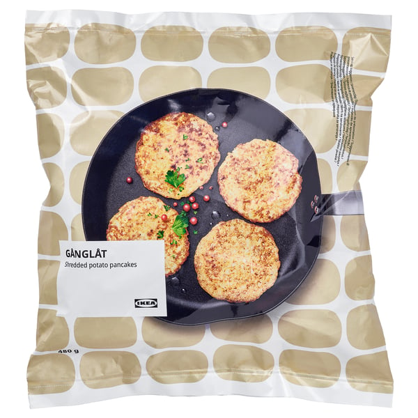 Ikeas GÅNGLÅT geraspte aardappelpannenkoekjes verpakt, met vier pannenkoeken op een zwarte koekenpan met garnering.