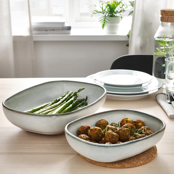 Twee ovenvaste kommen met eten op een tafel. De ene heeft asperges, de andere gehaktballen. Maakt deel uit van een stijlvolle, duurzame GLADELIG serie.