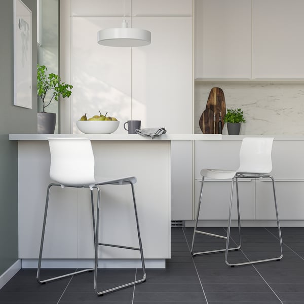 Moderne keuken met witte GLENN krukken. Strakke chromen poten, comfortabele witte stoelen. Hanglamp, potplanten, fruit op het aanrecht.