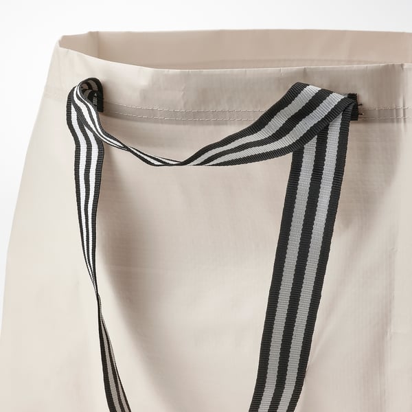 Close-up van duurzame beige tashandvatten met zwarte en witte strepen.