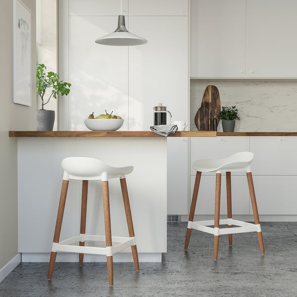 Moderne keuken met witte GRÖNSTA krukken. Strak ontwerp, houten poten, comfortabel voor de hoogte van de eetbar.