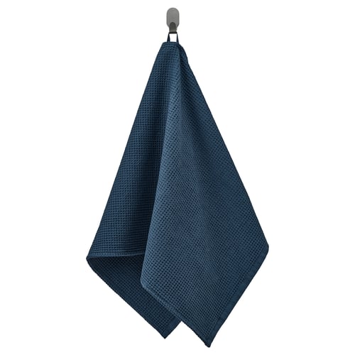 Een blauwe GULLDYNA-handdoek , gemaakt van gerecycled katoen, netjes hangend aan een haak en toont het getextureerde, rechthoekige ontwerp.