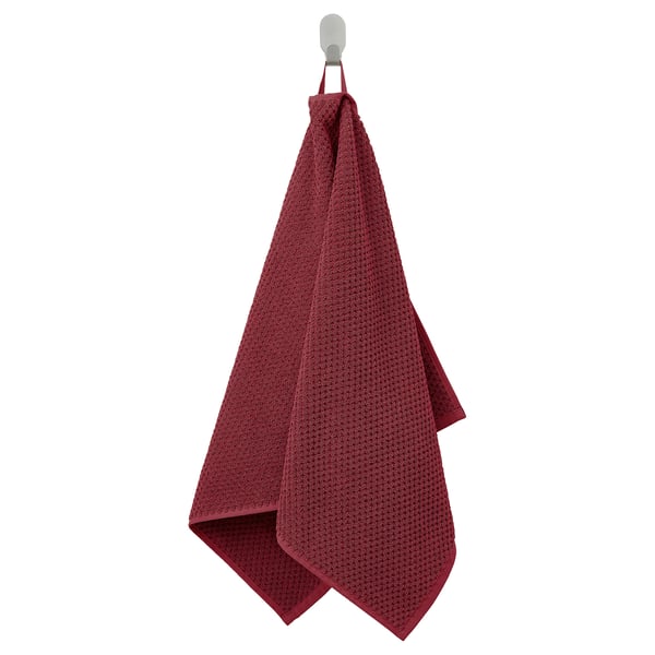 Een hangende kastanjebruine GULVIAL handdoek, zacht en dik, gemaakt van 100% katoen, rechthoekige vorm, netjes gedrapeerd aan een haak.