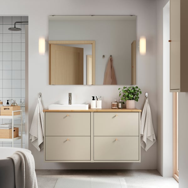 Moderne minimalistische badkamer met beige zwevende kaptafel, rechthoekige wastafel, spiegel en handdoeken.